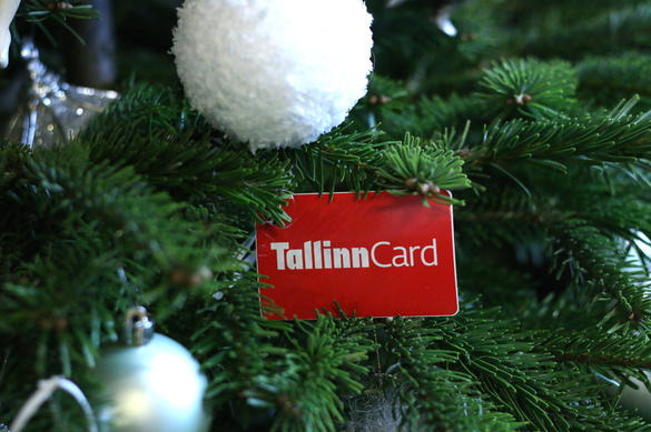 Christmas with Tallinn Card The red plastic Tallinn Card with white Christmas baubles and green spruce branches.